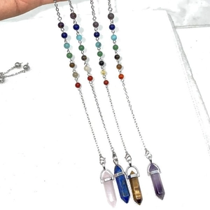 Natuurlijke kristallen zeshoekige hanger met chakra-kralen in de hand gehouden