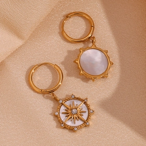 Détail de boucles d'oreilles étoile dorée 18k sur soie avec nacre et cristaux