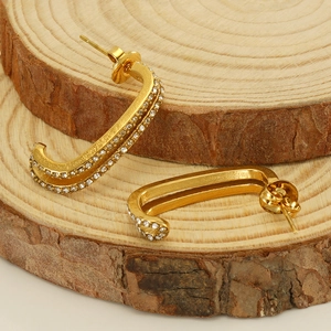 Gold double-layered U-shaped hoop earrings with pave-set zircon on natural wood base