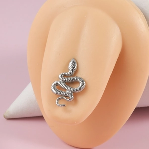 Close-up of silver snake stud earring made of stainless steel worn on an ear model