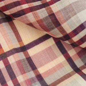 Gros plan sur la texture et le tissage du tissu en lin à carreaux rouge et beige