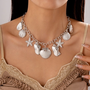 Silver ocean necklace with shell and starfish charms on a model, elegant beach style