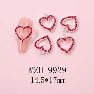 Macro view of silver hollow heart nail art charm with red rhinestones and 14.5x17mm size