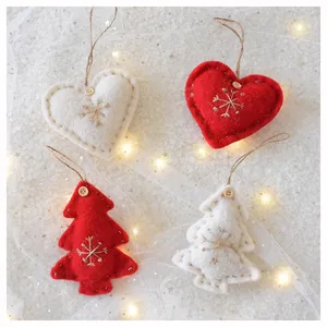 Macro detail of wool felt Christmas tree and heart ornaments with snowflake embroidery