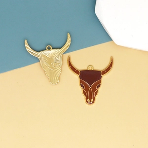 Detail of bull head charms in gold and brown enamel for Western DIY jewelry making