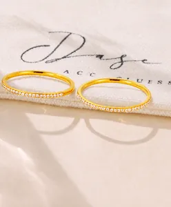 Détail macro d'une bague plaquée or avec zircons sur une pochette en tissu