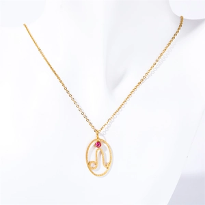 Detail of gold necklace with oval zodiac pendant and pink gemstone on white neck model