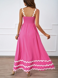 Detail of pink summer dress featuring scalloped white trim and smocked back design