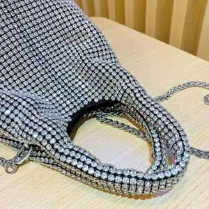 Close-up of luxury silver rhinestone handbag showing sparkling crystal details and metal chain
