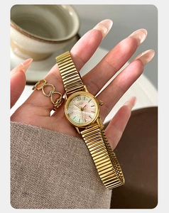 Detail of elegant gold watch with iridescent mother-of-pearl dial and Roman numerals