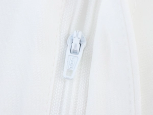 Close-up of high-quality white fabric zipper with polished metal puller and engraving