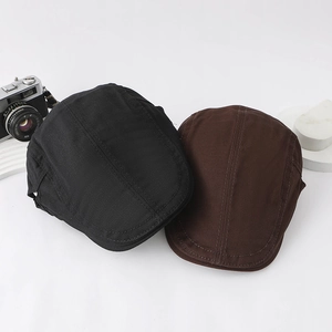 Flat lay of retro black and coffee cotton beret hats with vintage camera on white background