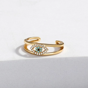 Detailed view of evil eye open ring featuring gold plating and blue cubic zirconia accents
