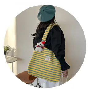 Close-up of a large yellow and blue striped plush tote bag featuring a cute dog pendant