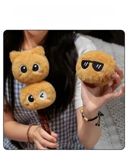 Detail of plush cat toy showing soft ginger faux fur texture and cute embroidered faces