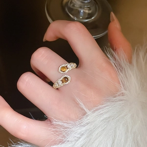 Detailed view of snake-shaped bypass ring with brown gemstones and micro-pave zircons