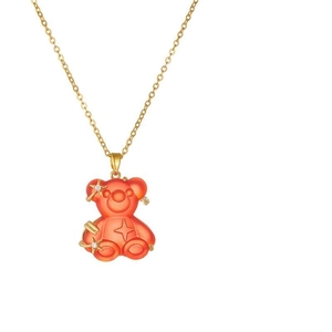 Detailed close-up of orange resin bear pendant with gold star inlay on a fine water-wave chain