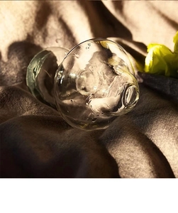 Macro shot of a Nordic transparent glass mushroom vase with water droplets on fabric