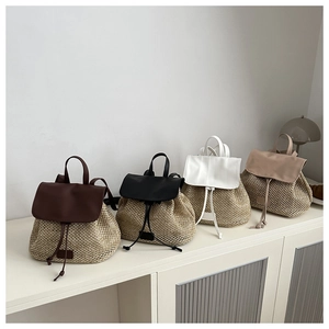 Straw patchwork backpacks in four colors shown on a white storage cabinet