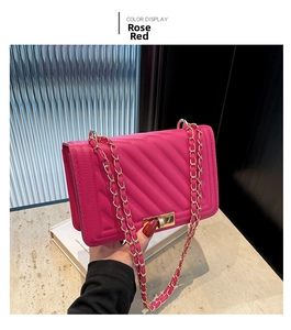Macro shot of rose red quilted faux leather bag with gold-tone metal twist lock closure