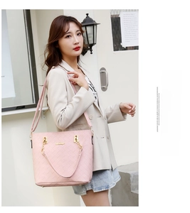 Pink woven tote bag with gold chain details and reinforced handles in street style view