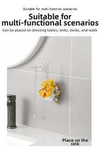 Close-up of diamond-shaped crystal L-hook holding hair ties and jewelry on a tile wall