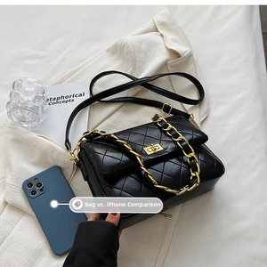 Detail of quilted black shoulder bag with gold chain and size comparison with iPhone
