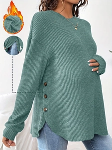 Detail of dark green maternity knit top with side buttons and warm fleece lining