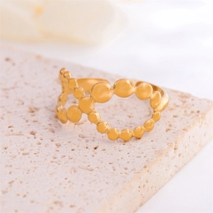 Adjustable 18K gold-plated stainless steel hollow bubble ring on a stone texture background