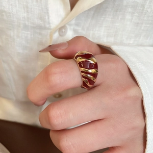Detailed view of vintage wide-band ring with red and gold enamel spiral texture