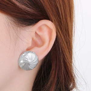 Detail von silbernen Spiral-Ohrsteckern am Model für einen trendigen Metallic-Look