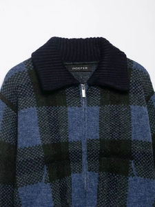 Detail of the knit zipper jacket showing the vintage plaid pattern and metal zipper hardware