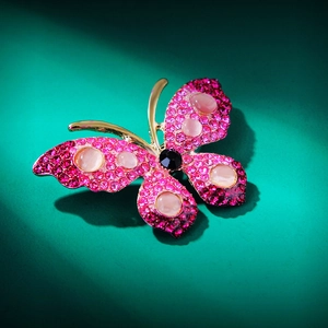 Detail of butterfly brooch with rose red rhinestones and pink cat eye stones