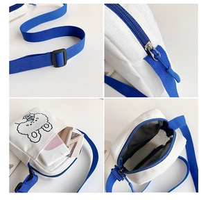 Detail view of small canvas crossbody bag with blue strap, zipper and animal pattern