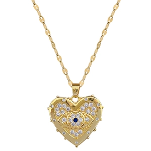 Titanium steel gold necklace with heart eye pendant and blue crystal on white background