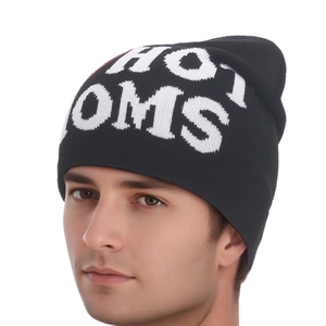 Close-up of black knitted beanie featuring white HOT MOMS jacquard lettering