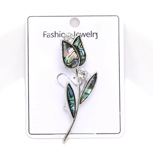 Detail of silver tulip brooch with colorful shell petals and sparkling rhinestones