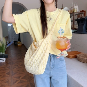Gros plan du sac à bandoulière jaune à carreaux avec un t-shirt à manches courtes à poche