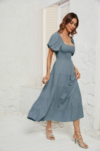 Détail des manches bouffantes et du bustier froncé sur une robe d'été bleue midi