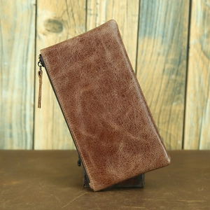Close-up of vintage brown crazy horse leather wallet texture and stitching detail