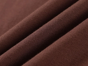 Macro detail of soft dark brown ribbed knit fabric showing fine texture and quality