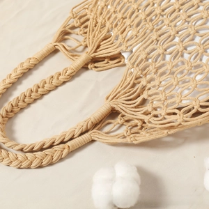 Detail showing handwoven hollow texture and reinforced handles of this straw tote bag