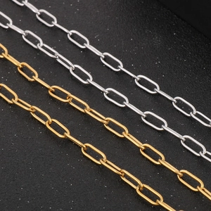 Macro shot of polished gold and silver oval link paperclip chains on dark background