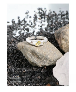 Macro detail of S925 sterling silver ring with yellow gemstone on natural stone