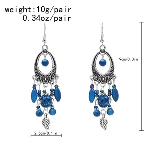 Detail of vintage bohemian silver earrings with blue spotted beads and leaf pendants