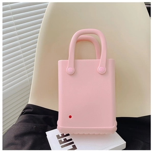 Detailansicht der pinkfarbenen EVA-Strandtasche mit Lochmuster auf einem weißen Stuhl