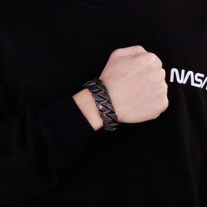 Détail d'un bracelet gourmette noir mat en acier inoxydable porté au poignet
