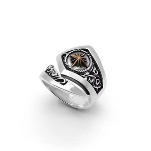 Macro detail of retro men's dagger shield ring with golden star and ornate carvings