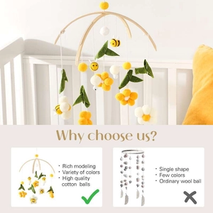 Detail of wooden baby mobile featuring yellow felt balls and handmade bees for crib decor
