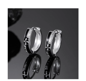 Detailed close-up of silver fleur-de-lis earrings with SPIRIT engraving and black enamel